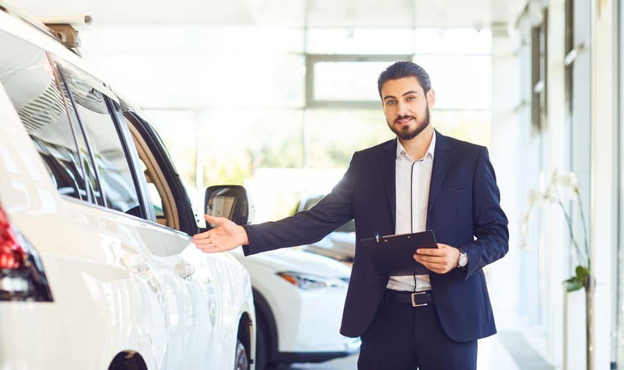 Un mandataire auto qui présente une voiture