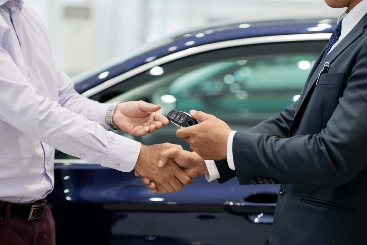 Un homme achète une Mercedes chez un vendeur auto