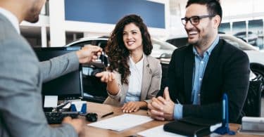 Une couple en train de contracter un financement pour acheter leur voiture