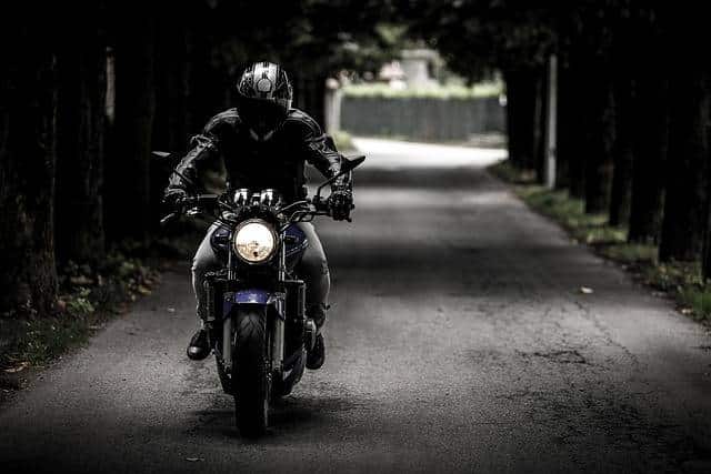 Un motard roulant sur une route avec sa moto