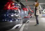 Une femme qui a garé sa voiture sur dans un parking d'aéroport pour partir en vacance