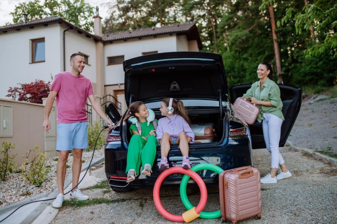 Une famille préparant la voiture pour partir en vacance