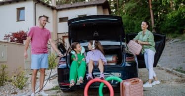 Une famille préparant la voiture pour partir en vacance