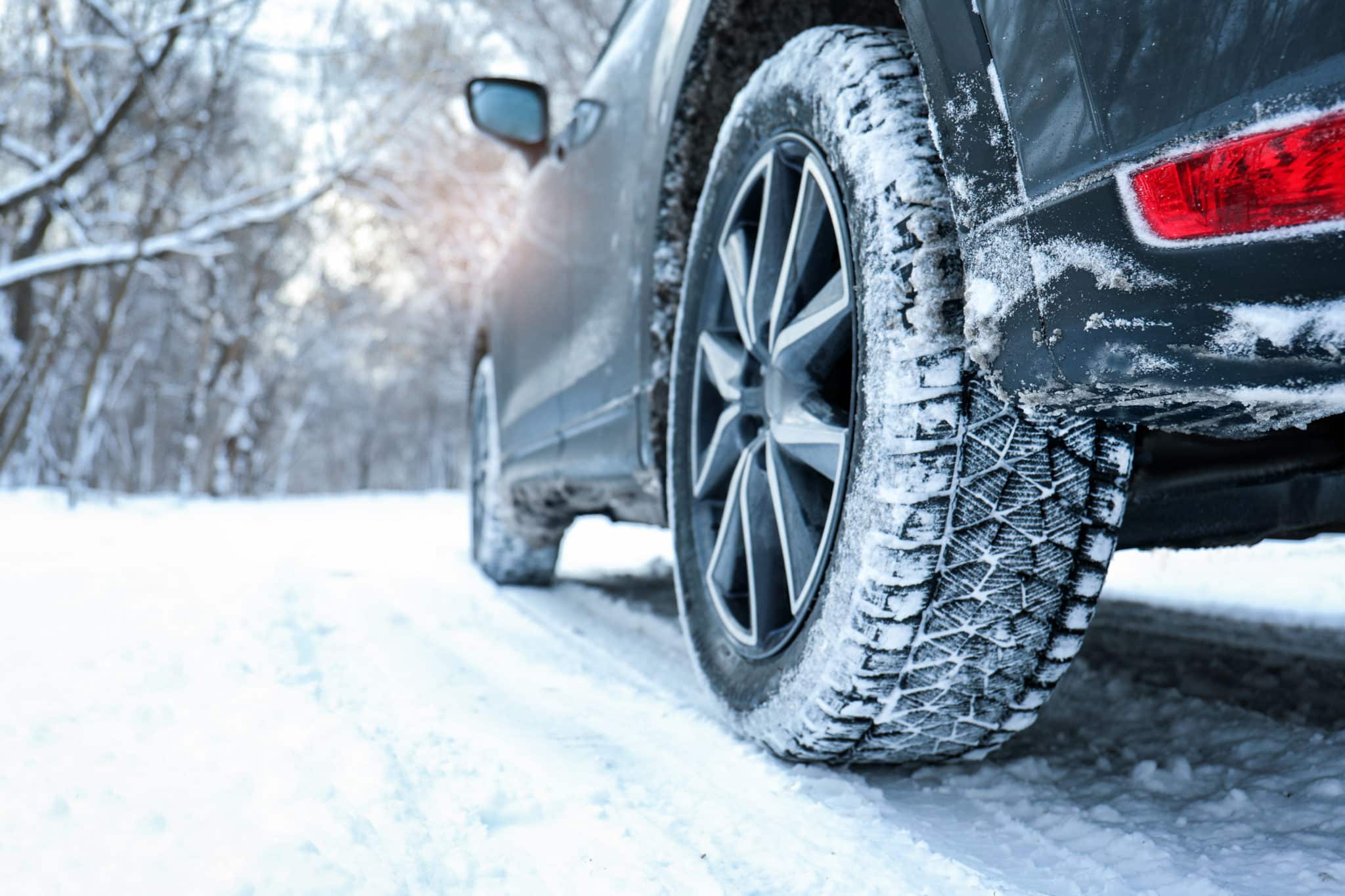 Une voiture avec des pneus hiver qui roule dans la neige