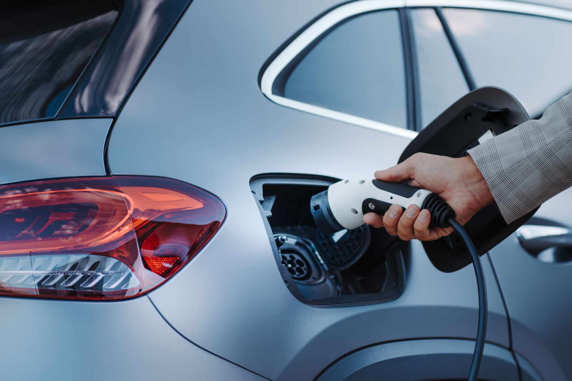 Personne branchant une voiture électrique